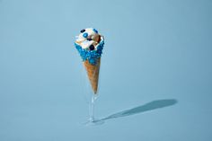 an ice cream cone with blue and white decorations on it's tip is shown in front of a light blue background