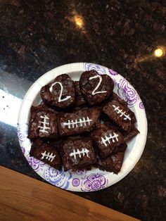 a bowl filled with brownies covered in chocolate and decorated with footballs on it