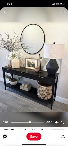 an image of a black console table with pictures on it and a lamp next to it