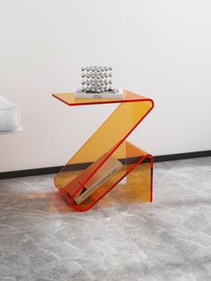 a glass table with a keyboard on top of it in front of a white wall