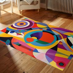 a brightly colored rug on the floor in front of a chair and radiator