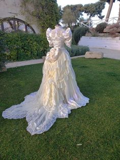 a white dress is on display in the grass