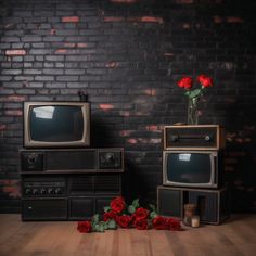 two old televisions with roses in front of them on a wooden floor next to a brick wall