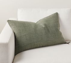 a green pillow sitting on top of a white couch