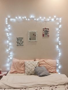 a bed that has some lights on the wall above it