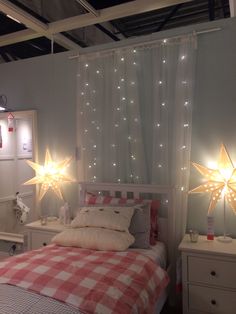 a bed room with a neatly made bed and stars on the wall