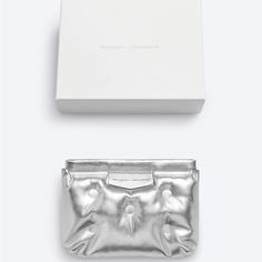 Maison Margiela X Gentle Monster Cushion Clutch Bag In Metallic Silver Faux Leather. New And Unused, Authentic. Part Of A Collaboration With Gentle Monster. Has A Self Closing Mechanism. Includes Original Box. Measures 7” Inches Tall X 8 3/4” Inches Wide. Luxury Silver Clutch With Removable Pouch, Luxury Pouch Clutch With Silver-tone Hardware, Luxury White Clutch Pouch, Margiela Bag, Gentle Monster, Martin Margiela, Metallic Silver, Clutch Bag, Original Box