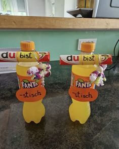 two plastic bottles with name tags on them are sitting on a counter top next to each other