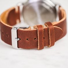 Our classic 2-piece custom watch straps feature Horween Leather in multiple color options with natural stitching. Straps feature a thumbnail style buckle and leather strap stays. As you wear your strap, you will notice how quickly it breaks in and molds to your wrist creating an incredibly comfortable fit. And with daily wear, it will deepen in color and patina becoming a piece completely unique to you.• Handmade watch band in Horween Leather• Simple stitching in Natural waxed polyester thread• Classic Watch Bands With Waxed Finish For Everyday Use, Leather Watches With Bracelet Strap And Round Dial, Leather Bracelet Strap Watch With Round Dial, Adjustable Leather Watch With Stainless Steel Clasp, Leather Bracelet Strap For Everyday Watch Use, Rugged Leather Watch Strap, Brown Leather Strap For Round Dial Watches, Leather Watches With Stainless Steel Clasp For Daily Wear, Leather Watches With Stainless Steel Clasp For Everyday Use