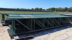 a large metal structure sitting on top of a dirt field