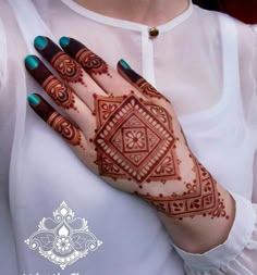 a woman's hand with henna tattoos on her left arm and the top half of her hands