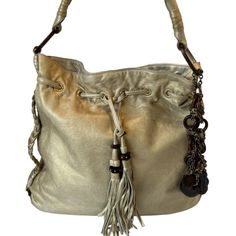 Authentic Juicy Couture Royal Couture Shoulder Bag Vintage Collectable Beautiful Bag ! Very Rare Htf Authentic Juicy Couture Leather Bag Y2k Made From Super Soft Leather And Is To Die For! The Color Is A Soft Light Gold Tone And The Leather Is Unbelievably Soft. Hardware Is Gold Tone (Brass) And Is Accented With Wood Beads And Leather Tassels. Large Wood Oval And Brass Rings Attach The Shoulder Strap. This Is A Used Bag But Shows Little Signs Of Wear. In Great Condition. Please See Photos For Imperfections. G&P In 1996 They Changed The Name To Juicy Couture. All Juicy Couture Items Are Manufactured With The Company Signature Logo: Two Highland Terriers Holding A Shield Bearing Three Hear Rare Juicy Couture Bag, Royal Couture, Bag Y2k, Shoulder Bag Vintage, Brass Rings, Juicy Couture Bags, Bag Vintage, Leather Tassel, Signature Logo