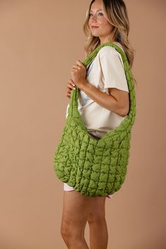 a woman is holding a green handbag