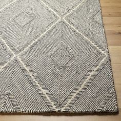 an area rug on the floor with wood floors in the background and a wooden floor