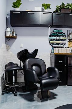 a black chair sitting in front of a hair dryer on top of a counter