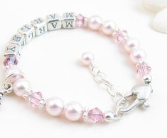 "Pink Beaded Name Bracelet for Child, Infant, Baby, or Little Girl: Created with pink Swarovski pearls and crystals and bright sterling silver spacers. Petite sterling silver alphabet beads spell out her name. The bracelet closes with a high-quality sterling silver heart-shaped lobster clasp with a 1/2\" \"Grow-with-Me\" extender chain. Choose one sterling silver charm. All metal components are sterling silver. Arrives packaged in my signature high-quality reusable canvas gift bag. Beautiful and Pink Beaded Bracelets For Birthday, Adjustable Pink Name Bracelet With 8mm Beads, Pink Beaded Name Bracelet For Birthday, Pink Birthstone Jewelry For Birthday, Hypoallergenic Pearl Jewelry For Birthdays, Pearl Jewelry For Baptism With Round Beads, Pink Birthstone Jewelry For Birthdays, Pearl Jewelry For Birthday And Mother's Day, Hypoallergenic Pink Jewelry For Birthday