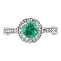 an emerald and diamond ring with white diamonds on the band, set in 18k white gold