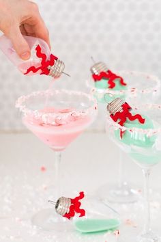 someone sprinkles red and green jello into martini glasses