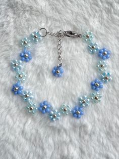 a bracelet with blue and silver beads on a white furnishce background, the bead is attached to a metal clasp