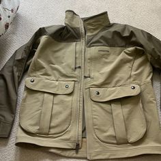 Light Tan/Dark Tan Men's Size L Jacket. Back Pocket With Zippers On Both Sides And Accessible From The Inside By Velcro. Front Full Length Zipper With Big Side Pockets (Both L & R Sides) And Zipper Pockets On Top Front (Both L & R Sides). Never Been Worn. Nwot. Gore-tex Outdoor Outerwear With Pockets, Gore-tex Long Sleeve Outerwear For Outdoor Work, Patagonia Brown Outerwear For Outdoor Activities, Patagonia Outerwear For Hiking, Midweight Outerwear With Pockets For Hiking, Midweight Hiking Outerwear With Pockets, Vintage Windbreaker Jacket, Purple Vests, Mens Down Jacket