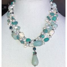 the necklace is adorned with pearls and green glass beaded beads on a mannequin