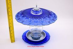 a blue glass dish with a measuring tape next to it