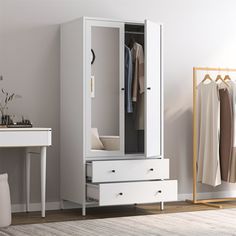 a white armoire with drawers next to a desk and mirror on the wall in a room