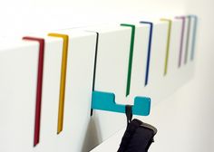 a row of colorful magnets attached to a white wall next to a cell phone