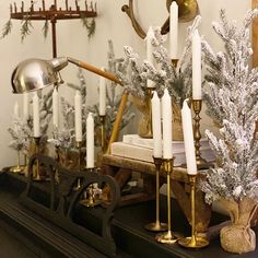 a mantle with candles and christmas decorations on it