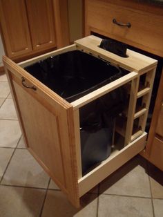 an open cabinet in the middle of a kitchen floor