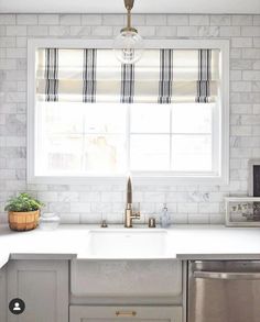 a kitchen with a sink, dishwasher and window