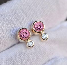 Super cool pink tourmaline and diamond stud earrings set in 14k gold embody timeless elegance. Tiny minimal earrings which are great for young girls or for those who like to keep it simple. Excellent as a birthday gift and great for daily wear too! Size : 10x6mm Material : 14k Gold Gemstones : Pink Tourmaline, 0.06 CTW Diamond Packaging : All products purchased from us come in a gift box. If you need to include a message, kindly leave us a note when purchasing.  Care Recommendations:  When not in use, keep earrings enclosed in a box or pouch to minimize exposure to moisture in air. Do not spray aromatics directly onto product. Minimize exposure to water. Clean with a soft cloth when required. Diamond Packaging, Minimal Earrings, Earring Gift, Pink Gemstones, October Birthstone, Diamond Stud, Stud Earrings Set, October Birth Stone, Stud Earring