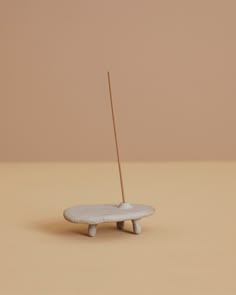 a small white object with a wooden stick sticking out of it's center piece