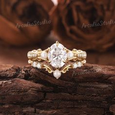 a close up view of a ring with pearls and diamonds on the side, sitting on a piece of wood