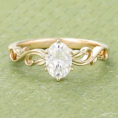 a yellow gold engagement ring with an oval cut diamond in the center and twisted band