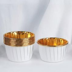 four white and gold dishes stacked on top of each other in front of a white background