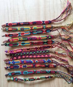 there are many colorful bracelets laid out on the table