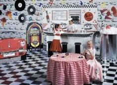 two women are sitting at a table in a room with record records on the wall