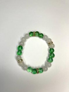 Green and off white handmade beaded bracelet with gold accents. Stylish accessory Cheap Nickel Free Green Bracelets, Cheap Green Beaded Bracelets, Cheap Green Beaded Friendship Bracelets, Cheap Green Bracelets For Holiday, Green Pearl Bracelet, White Spiritual Bracelets With Colorful Beads, Spiritual White Bracelets With Colorful Beads, White Jade Beaded Bracelets With 8mm Beads, Hand-strung White Jade Beaded Bracelets