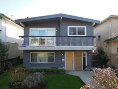 a two story house with balconies on the second floor and an attached balcony