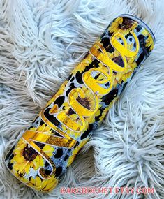 a yellow and black can with the word sunflower on it sitting on white fur