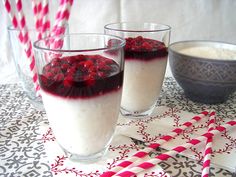 two glasses filled with dessert sitting on top of a table