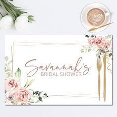 a floral bridal shower sign next to a cup of coffee