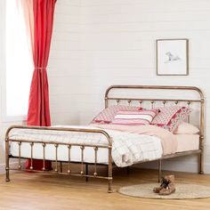 a metal bed frame in a white bedroom with red drapes on the windowsill