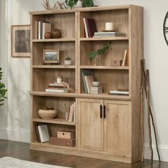 a wooden bookcase filled with lots of books on top of a hard wood floor