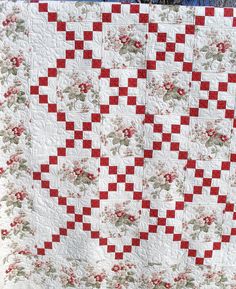 a large red and white quilt on display