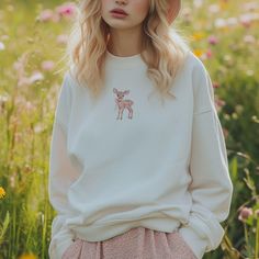 ⭐Indulge in the dreamy allure with our Coquette Aesthetic Sweatshirt of a whimsical fawn reminiscent of vintage children's books  (also available as a Unisex tshirt or 90s Baby Tee). Your item will be made to order just for you, the sustainable way 🌿.    Please note, colors and images may vary slightly from picture images -----------Please note, the graphics are on the front of the t-shirt.  If you would the image to be on the back, please contact me before purchasing as this is a made to order product.  This change is free of cost to make --------- ⭐This is a made to order product and WE CANNOT ACCEPT RETURNS unless there is a physical defect with the order. Please read returns policy. If there is an issue with the product please contact me within 3 days of receiving the item with pictur Oversized White Y2k Sweatshirt, White Y2k Crew Neck Sweater, White Y2k Cotton Sweatshirt, Oversized Y2k Sweatshirt For Spring, White Cotton Y2k Style Sweatshirt, White Y2k Style Spring Sweater, Y2k Crew Neck Sweatshirt For Fall, Y2k Fall Crew Neck Sweatshirt, Cute White Relaxed Fit Sweater