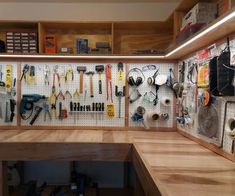 a workbench with many tools hanging on the wall