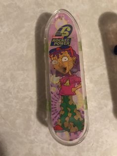 a cartoon character is on the back of a skateboard in a plastic case with its lid open