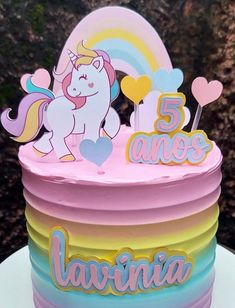 a birthday cake with an unicorn on top and rainbow decorations around the edges that says, 5 ams lavinia